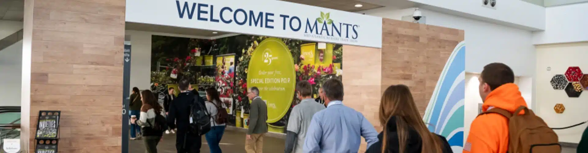 People enter an event space under a sign that reads 